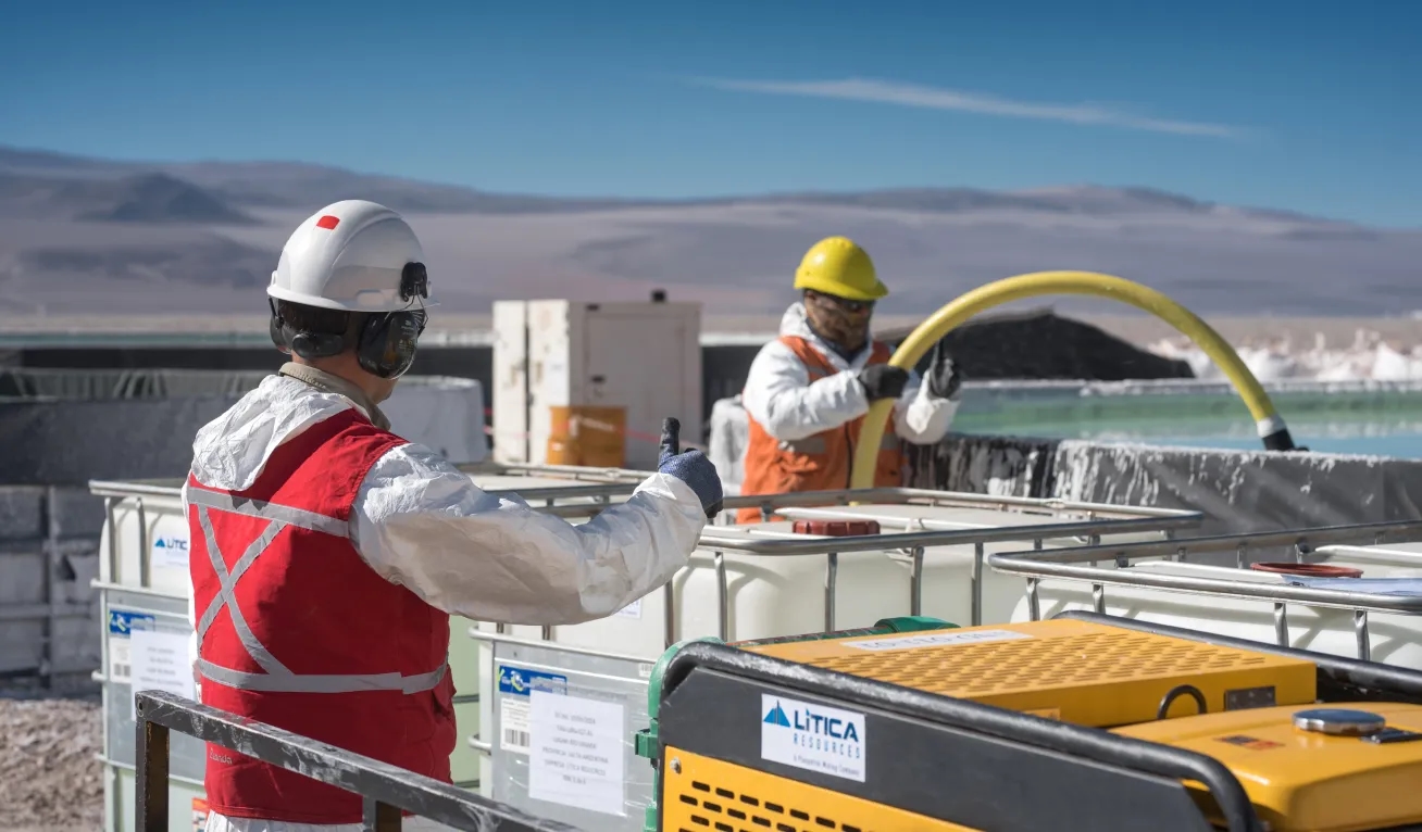 Tres personas mirando una computadora en el patio exterior de una oficina